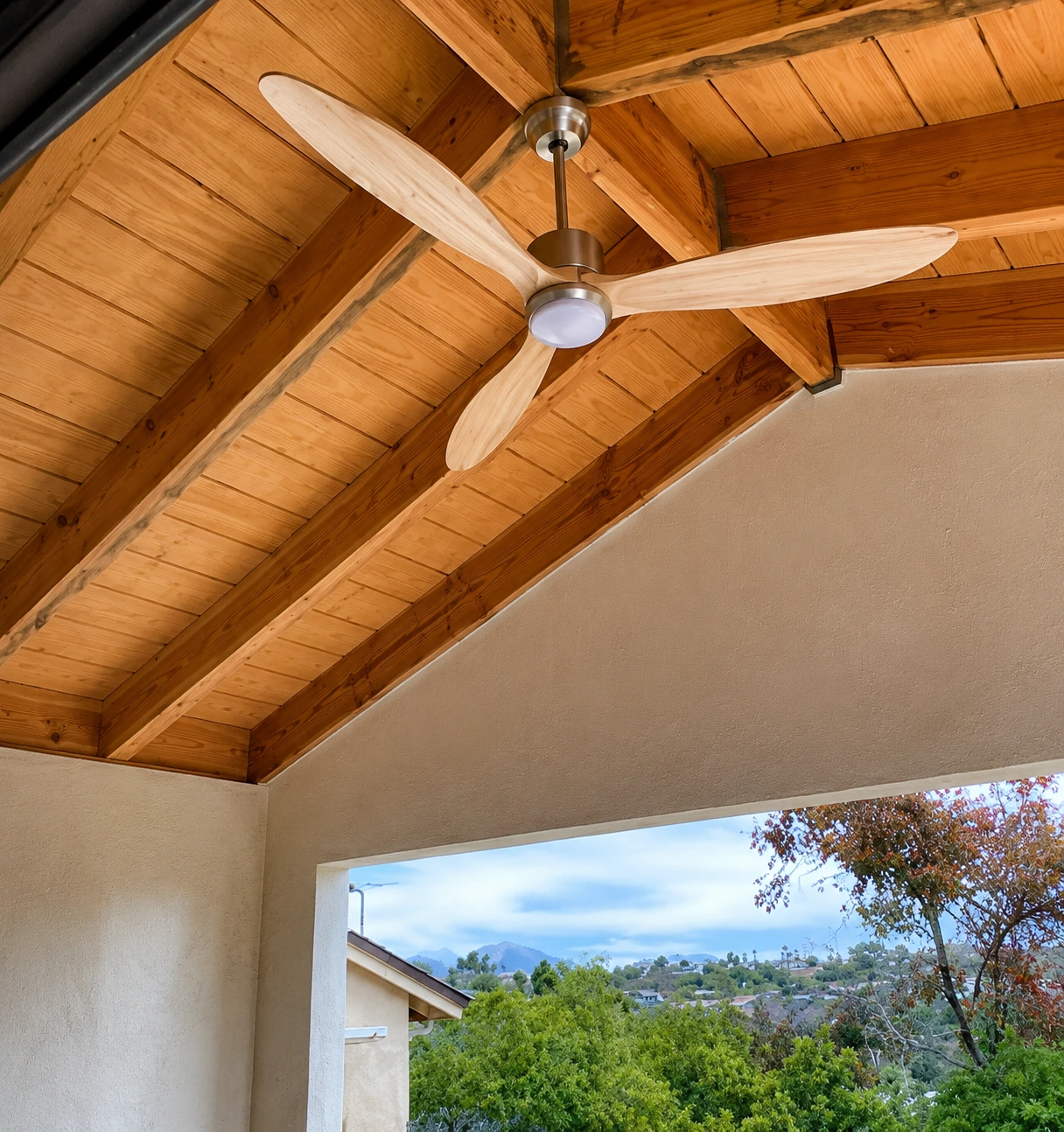 Covered rear patio with an exposed wood ceiling and ceiling fan.